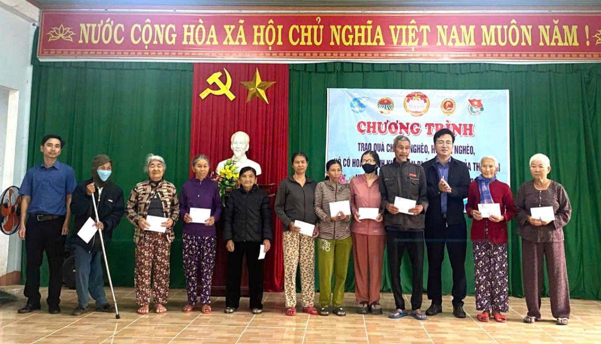 Lãnh đạo xã Quế Sơn Trung trao quà cho người dân.