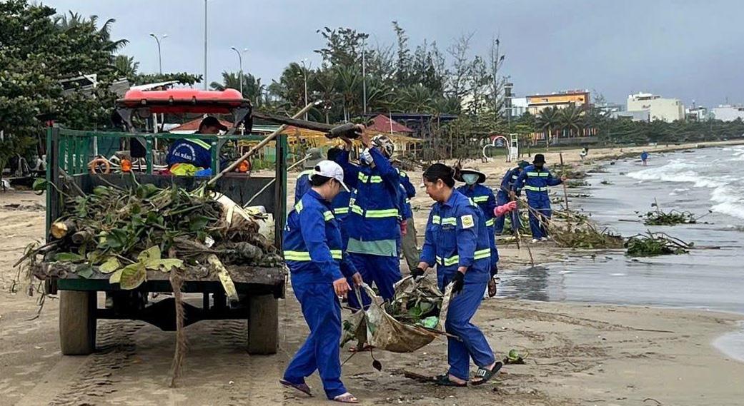 Công nhân môi trường đô thị thu gom rác tấp vào bãi biển.